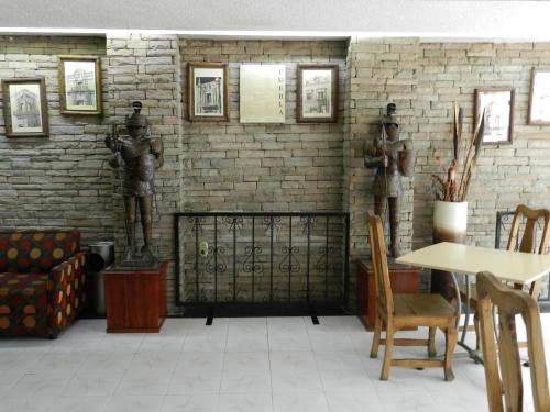 a room with two statues on a brick wall at Hotel San Miguel in Puebla