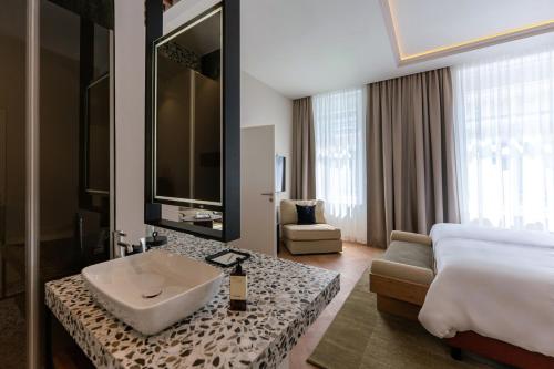 a hotel room with a sink and a bed at LOVIS Suites Vienna in Vienna