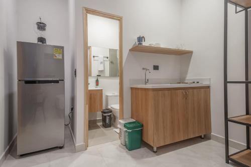a small kitchen with a sink and a refrigerator at NOK Home Tree Living in Medellín
