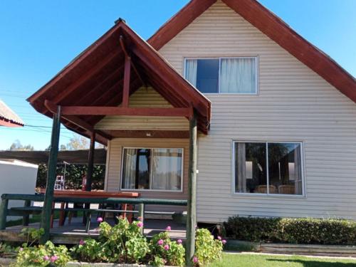 a house with a porch and a bench in front of it at Cabañas Villa Alejandra in Las Cabras