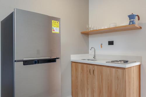 a kitchen with a refrigerator and a sink at NOK Home Tree Living in Medellín