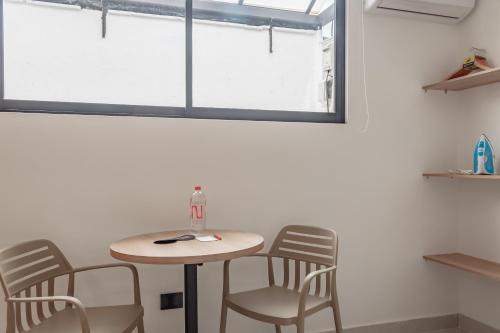 a table and chairs in a room with a window at NOK Home Tree Living in Medellín
