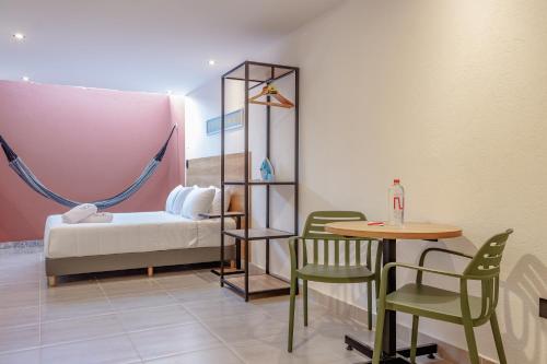 a room with a bed and a table and chairs at NOK Home Tree Living in Medellín