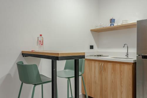 a kitchen with two green chairs and a counter at NOK Home Tree Living in Medellín