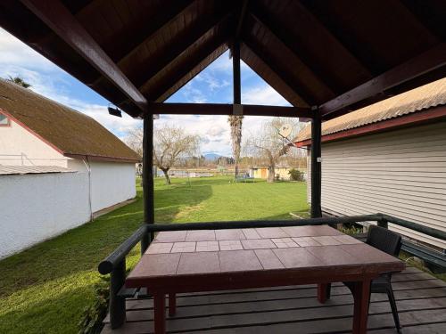 a picnic table on a porch with a roof at Cabañas Villa Alejandra in Las Cabras