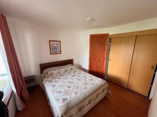 a small bedroom with a bed and a wooden cabinet at Cabañas Villa Alejandra in Las Cabras
