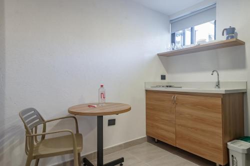 a small kitchen with a table and a sink at NOK Home Tree Living in Medellín