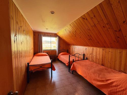 a room with three beds and a window at Cabañas Villa Alejandra in Las Cabras