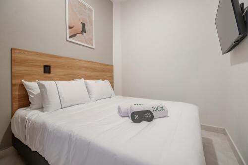 a white bed with a camera on top of it at NOK Home Tree Living in Medellín