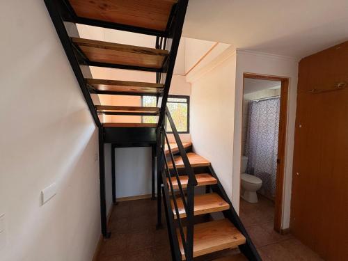 a spiral staircase in a room with a toilet at Cabañas Villa Alejandra in Las Cabras