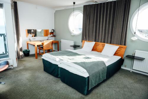 a bedroom with a large bed and a table at Nyborg Strand Hotel & Konference in Nyborg