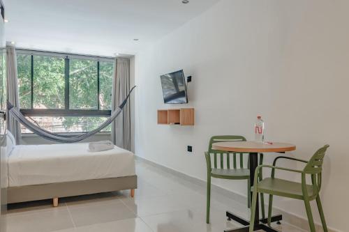 a bedroom with a bed and a table and a window at NOK Home Tree Living in Medellín