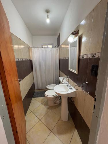 a bathroom with a toilet and a sink and a mirror at Complejo Sucre I in San Luis