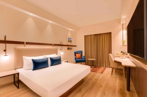 a hotel room with a bed and a desk and a computer at Hotel The Tark Near IGI Airport Delhi in New Delhi