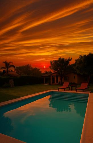 a sunset over a swimming pool at sunset at Descanso de Caroya in Colonia Caroya