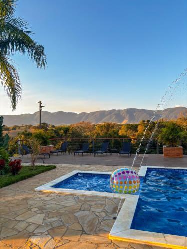a swimming pool with a water fountain at Chácara Pôr do Sol in Andradas