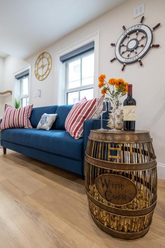 a living room with a blue couch and a barrel with wine bottles at North End Entire House in Boston