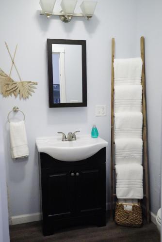 a bathroom with a sink and a mirror and towels at Coastal 3-BR Lower Near Lake MI and Downtown Sheboygan in Sheboygan