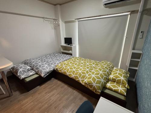 a small bedroom with two beds and a desk at Residence Airport 806 - Vacation STAY 19996 in Miyazaki