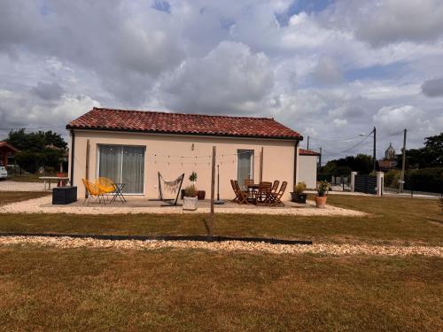 a small white house with a table and chairs at Polypocket in Saint-Laurent-des-Vignes