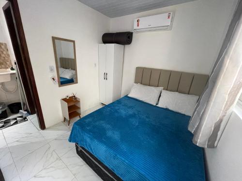a bedroom with a bed with a blue blanket at Casa de praia Rocha Alves em Porto de Galinhas in Porto De Galinhas