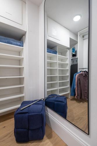a walk in closet with a large mirror and blue ottoman at North End Entire House in Boston