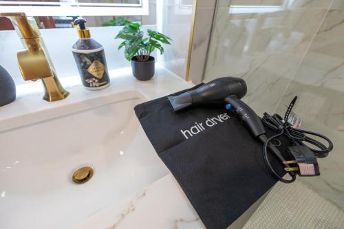 a hair dryer sitting on a bathroom sink at North End Entire House in Boston