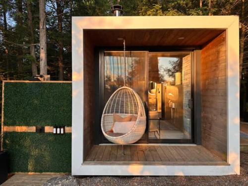 a wicker chair sitting inside of a house at Aux Box Muskoka Modern Muskoka Bunkie in Huntsville