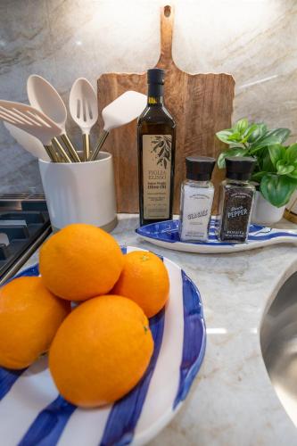 a plate of oranges on a counter with a bottle of alcohol at North End Entire House in Boston