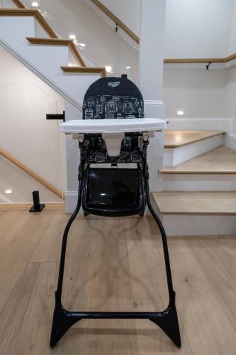 a chair with a surfboard on top of it in front of stairs at North End Entire House in Boston