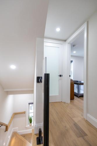 a hallway with a black refrigerator in a house at North End Entire House in Boston