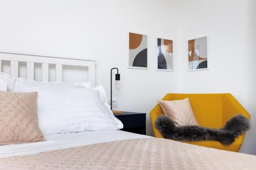 a bedroom with a bed and a yellow chair at Villa Nova in Podstrana