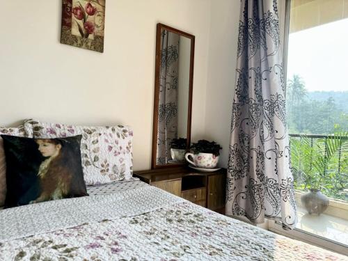 a bedroom with a bed and a window at Amber- Sun-Kissed Holidays, Goa in Chicalim