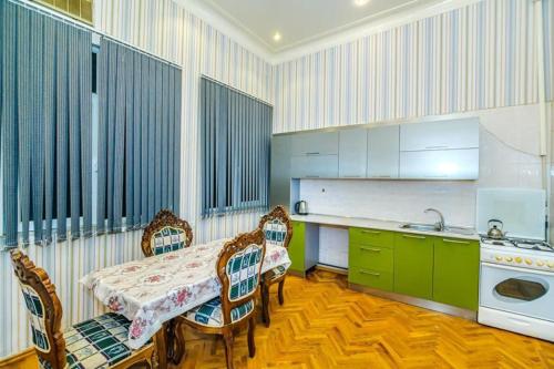 a kitchen with a table and chairs and a sink at Nizami Hostel in Baku