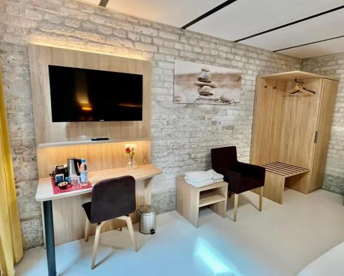 a room with two chairs and a desk and a tv at Adlzreiter City Pension in Munich