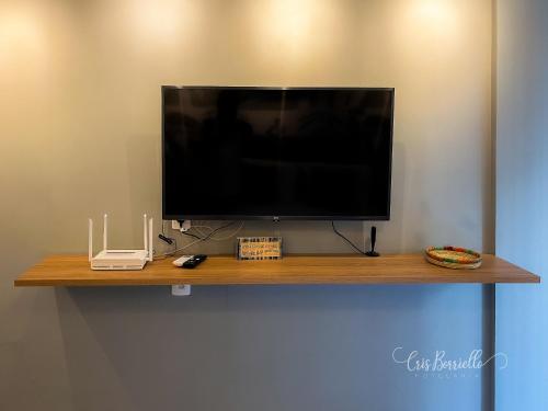 a flat screen tv sitting on top of a wooden shelf at Skylux Studios de Luxo in Rio de Janeiro