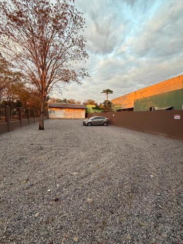 a car parked in a parking lot next to a tree at Pousada Maritaca in Bonito