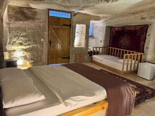 a bedroom with a large bed and a door at My Cave Suites in Nevsehir