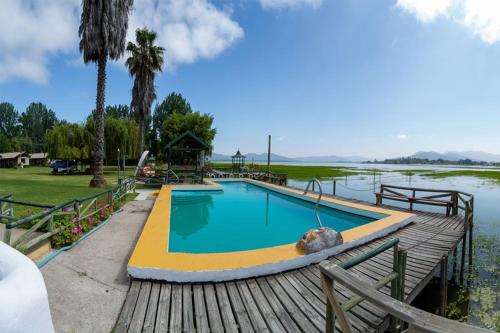 a swimming pool on a wooden deck next to a body of water at Cabañas Villa Alejandra in Las Cabras