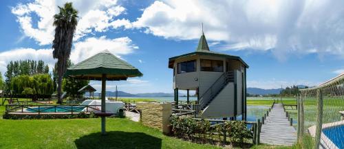 a tree house with a staircase next to a body of water at Cabañas Villa Alejandra in Las Cabras