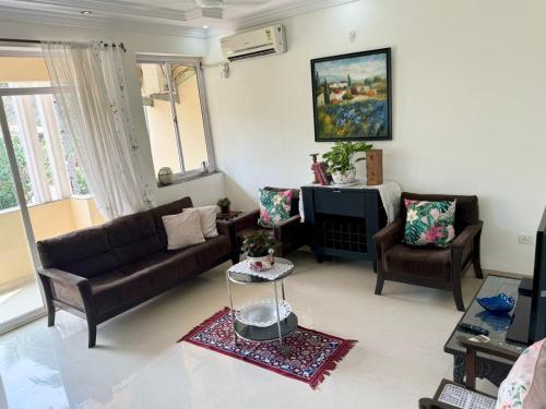 a living room with a couch and two chairs at Amber- Sun-Kissed Holidays, Goa in Chicalim