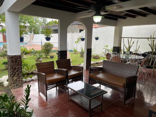a patio with wicker chairs and a table at Majagual Beach House in Veracruz
