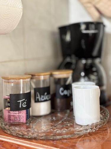 a glass tray with four containers on a counter with a cup at Majagual Beach House in Veracruz