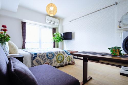 a living room with a bed and a table at MIYAVI#302 3min walk Narimasu Station, 4 people, wide queen bed & sofa, Tokyo's largest Don Quijote in Tokyo