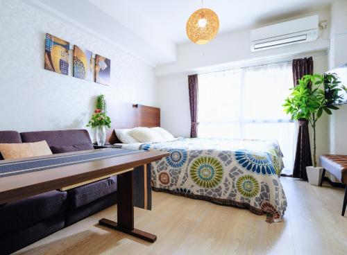 a living room with a bed and a couch at MIYAVI#302 3min walk Narimasu Station, 4 people, wide queen bed & sofa, Tokyo's largest Don Quijote in Tokyo