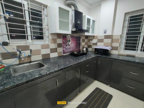 une cuisine avec un évier et un plan de travail dans l'établissement Cozy 3BHK Stay Near US Consulate, Nallagandla, à Hyderabad