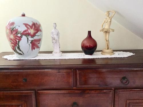 three vases and statues sitting on a wooden dresser at Amber- Sun-Kissed Holidays, Goa in Chicalim