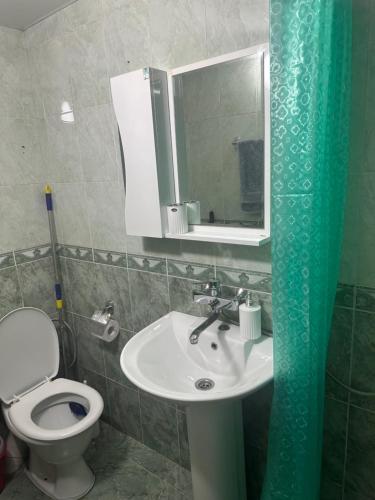 a bathroom with a toilet and a sink and a mirror at Bella in Tbilisi City