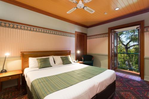 um quarto com uma cama grande e uma janela em Manly Hotel em Brisbane