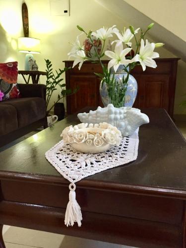 a table with a vase of flowers on top of it at Amber- Sun-Kissed Holidays, Goa in Chicalim